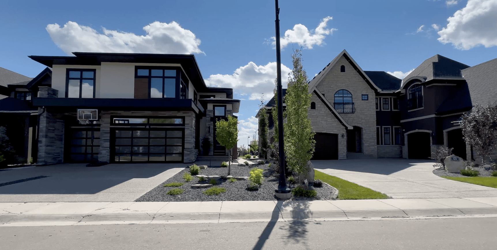 Modern residential street in West Calgary showcasing upscale homes and quiet tree-lined sidewalks